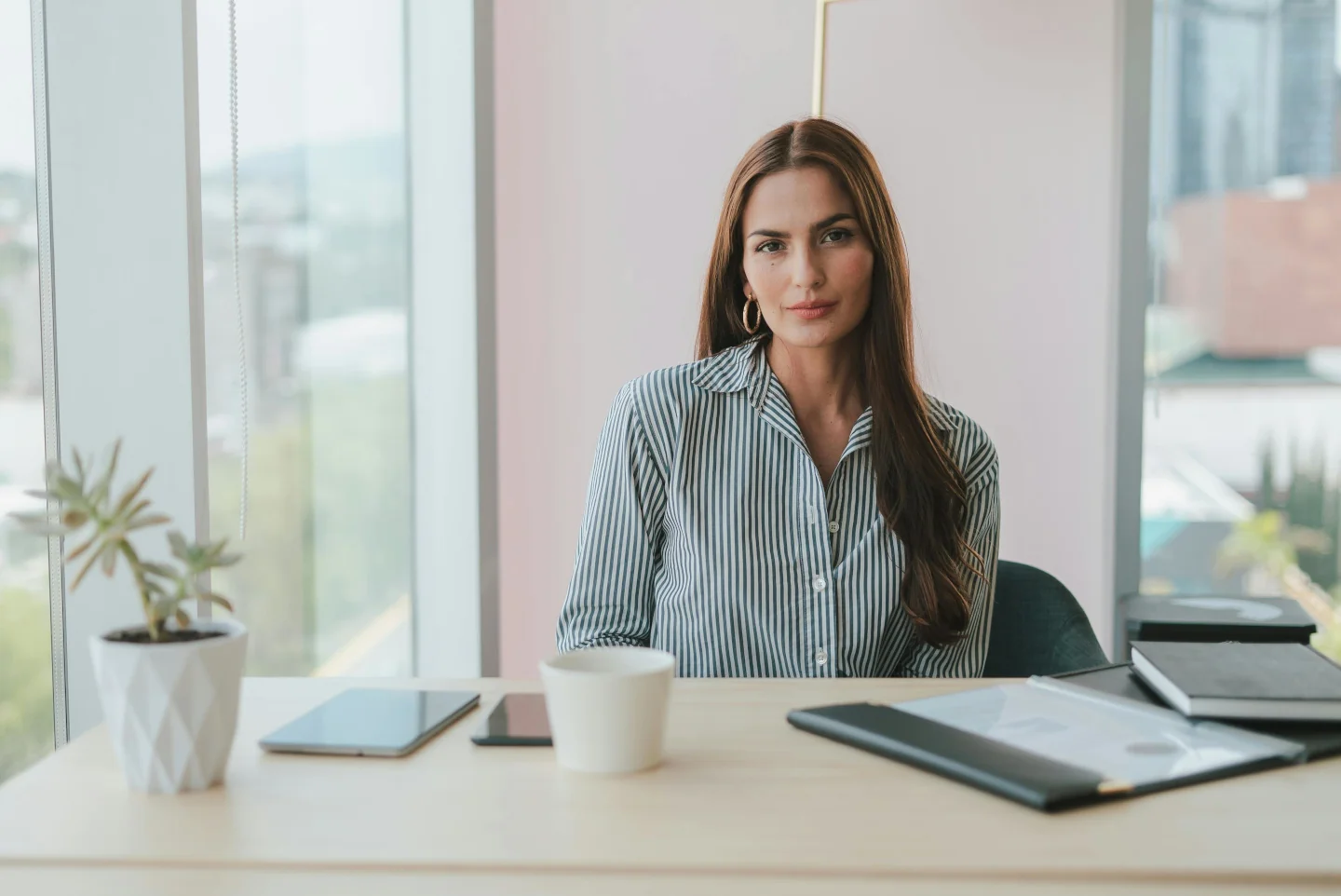 A businesswoman sitting behind a desk in a modern office