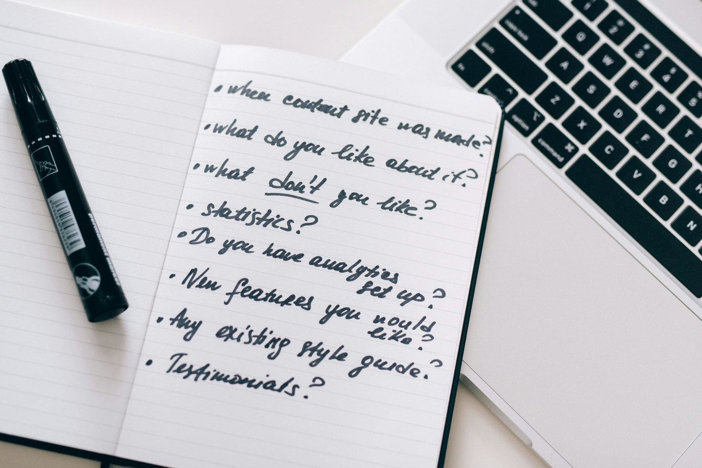 A marker on top of an open notebook with feedback questions